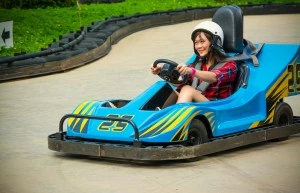 Teenage girl driving a go kart near our condo rentals in Pigeon Forge with pool access.